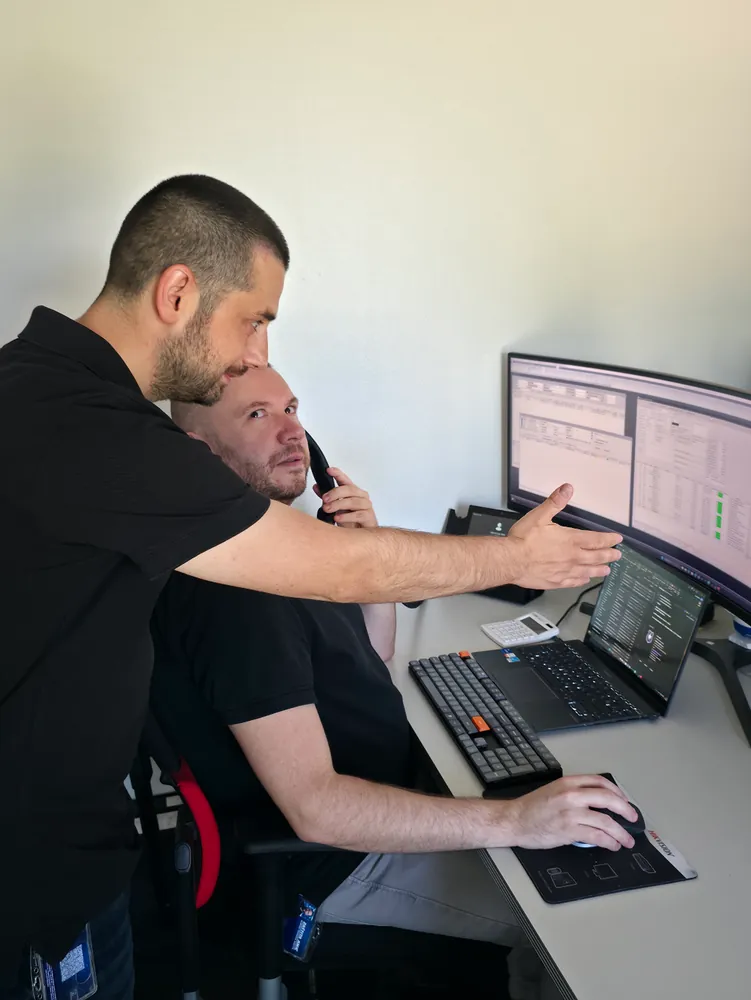 Dvojica djelatnika Zaštite Jukić zajedno gledaju radni nalog na monitoru, jedan usporedno razgovara telefonom
