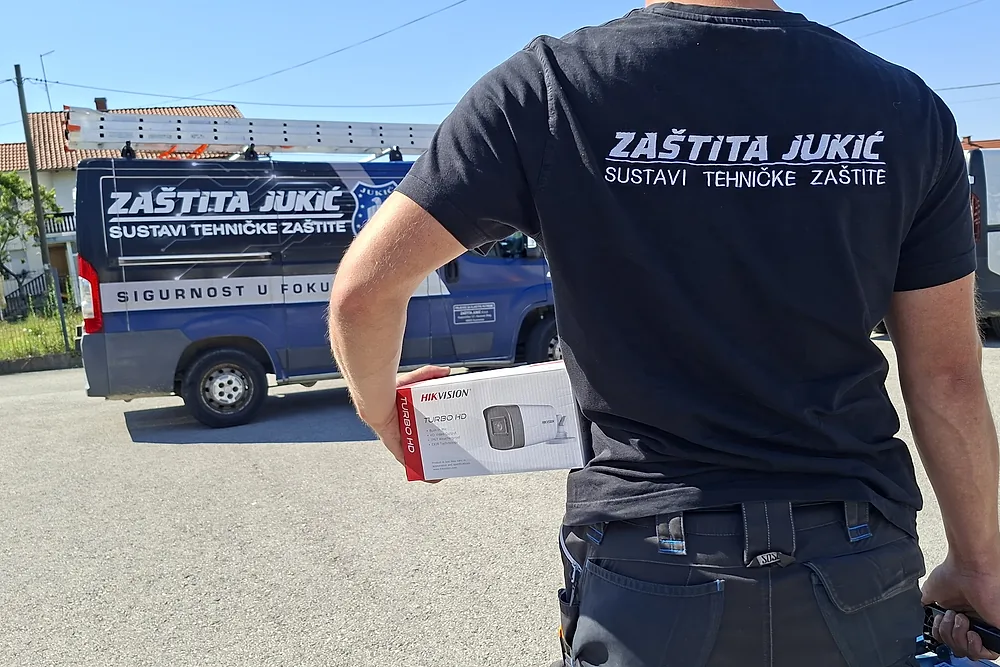 Tehničar Zaštite Jukić nosi kameru videonadzora prema servisnom kombiju