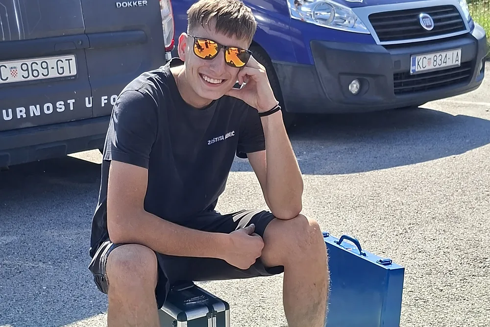 Mladi tehničar Zaštite Jukić s kovčezima alata nakon montaže na terenu